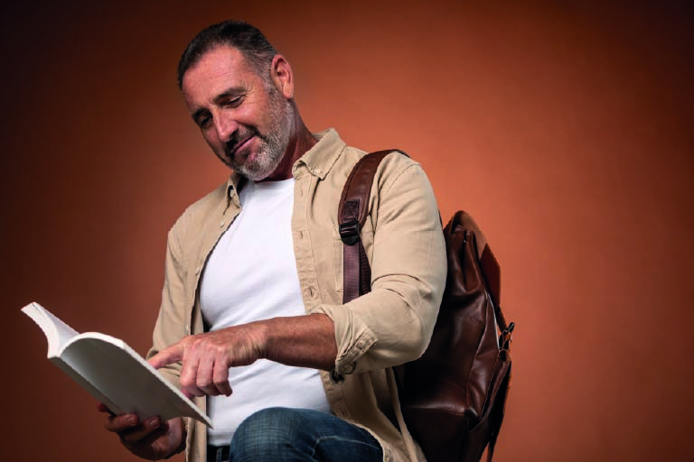 Homem apontando para algo em seu livro. 10 livros sobre a metodologia bilíngue que você precisa conhecer
